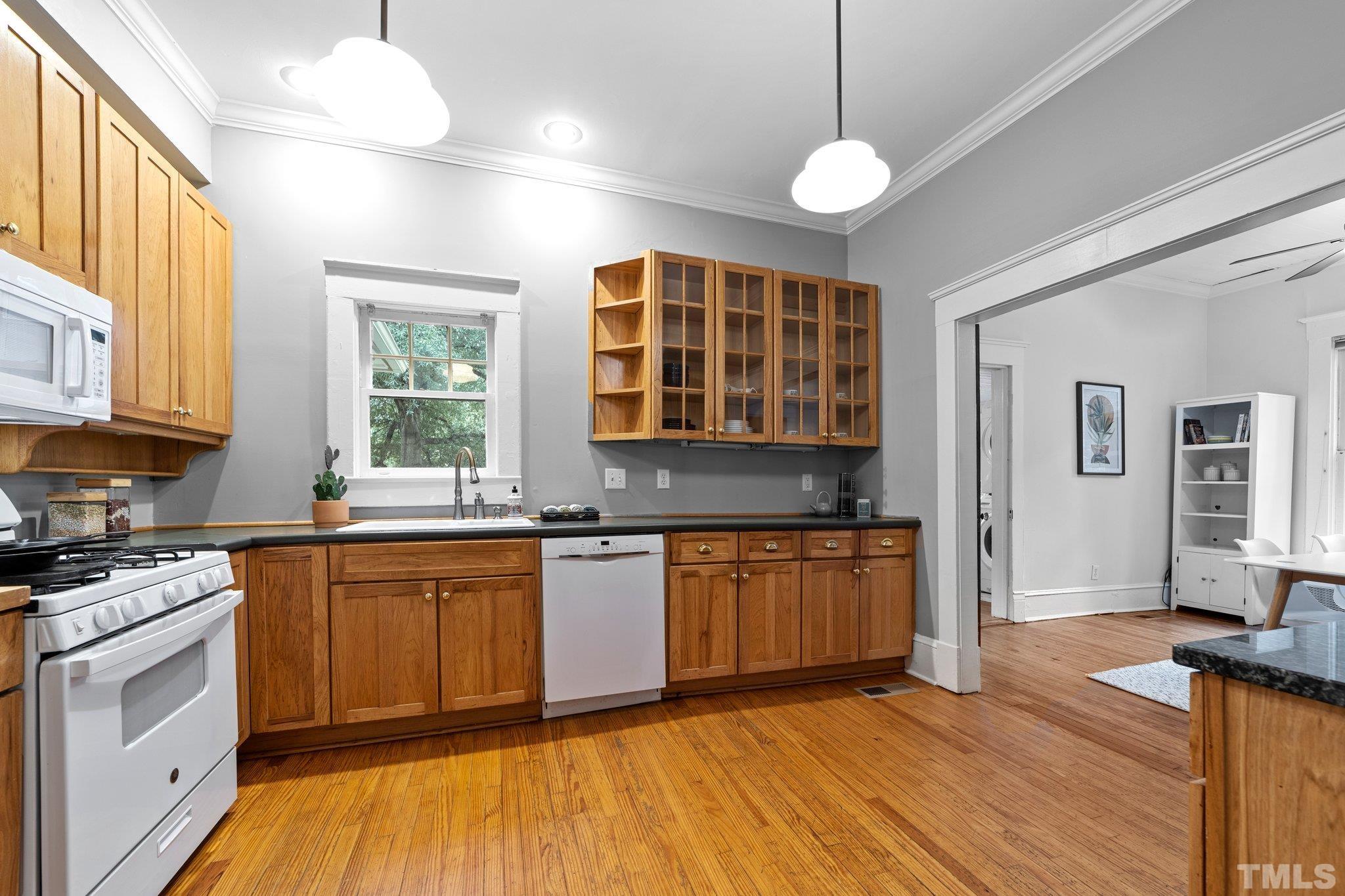 801 Onslow Street Durham, NC 27705 - Photo 13 of 30 a kitchen with stainless steel appliances granite countertop a stove a sink dishwasher and white cabinets with wooden floor