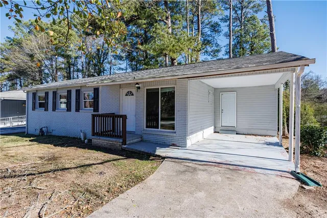 front view of a house with a large window and a bench