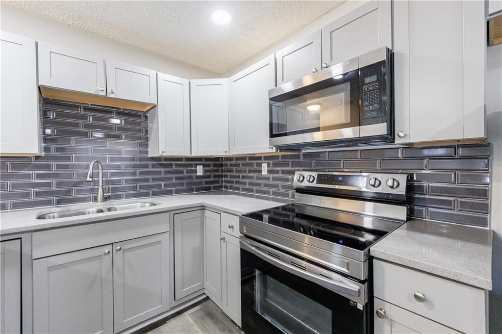 779 Amber Place Northwest Atlanta, GA 30331 - Photo 14 of 35 a kitchen with stainless steel appliances a stove sink and cabinets
