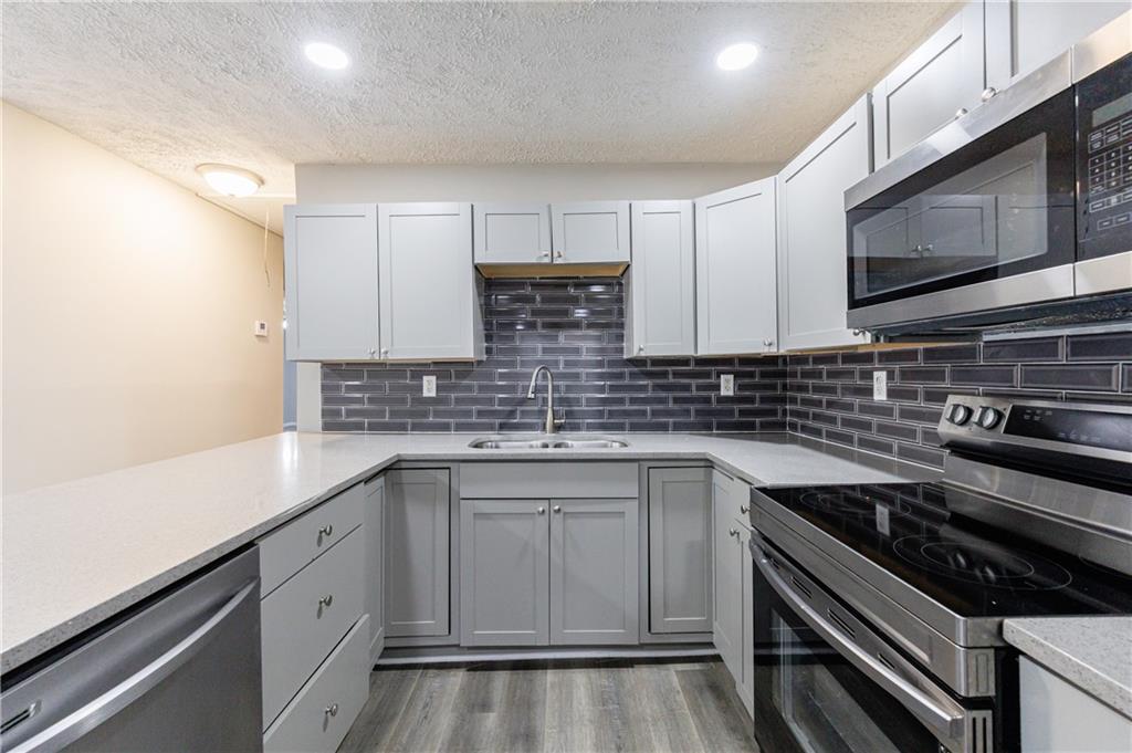 779 Amber Place Northwest Atlanta, GA 30331 - Photo 15 of 35 a kitchen with stainless steel appliances a sink dishwasher stove microwave and cabinets