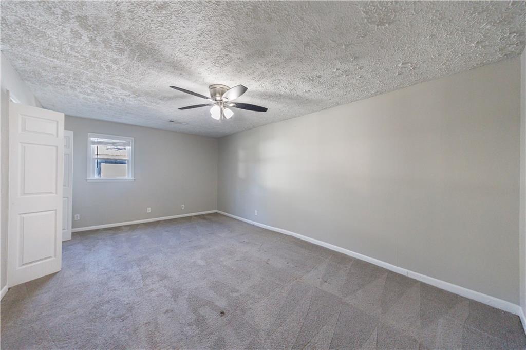 779 Amber Place Northwest Atlanta, GA 30331 - Photo 27 of 35 an empty room with a chandelier fan and windows