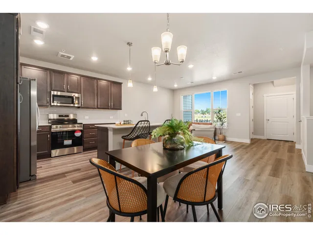 a kitchen with stainless steel appliances kitchen island granite countertop a sink refrigerator and cabinets
