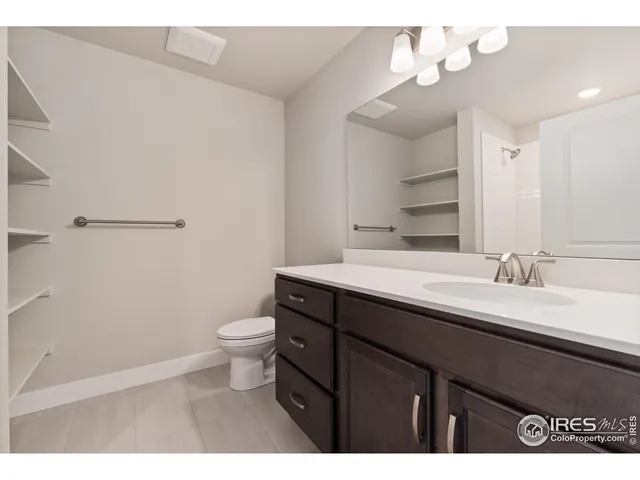 a bathroom with a granite countertop sink a toilet and a mirror