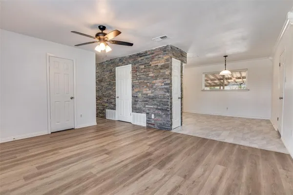 a view of empty room with wooden floor and ceiling fan