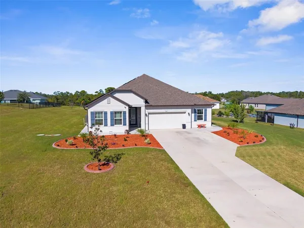 a front view of house with yard and mountain view in back