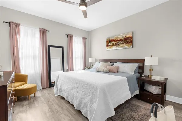 a spacious bedroom with a bed and a flat screen tv