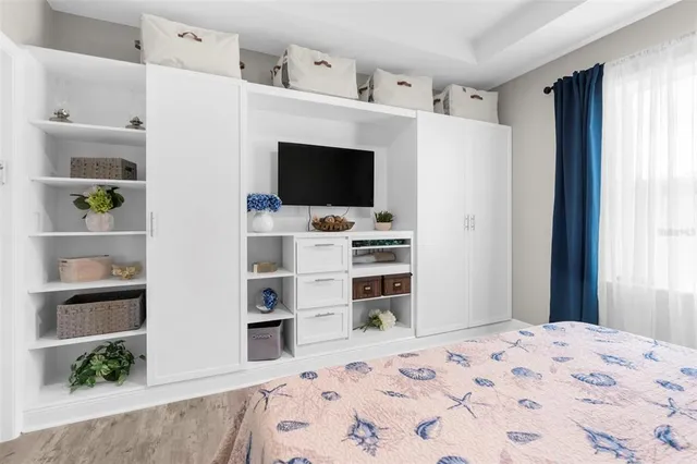 a bedroom with a bed and a flat screen tv