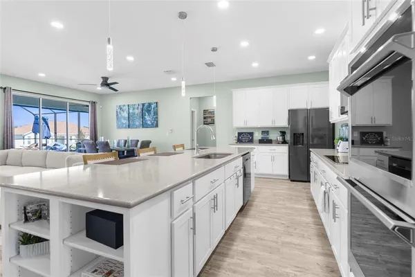 a kitchen with stainless steel appliances granite countertop a stove a sink a microwave a center island and a refrigerator