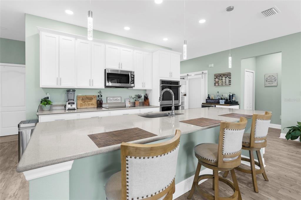 9347 North Star Court Weeki Wachee, FL 34613 - Photo 19 of 46 a kitchen with stainless steel appliances granite countertop a stove a sink a microwave a center island and a refrigerator