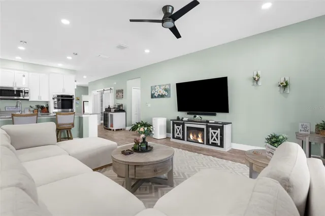 a living room with furniture a flat screen tv and a large window