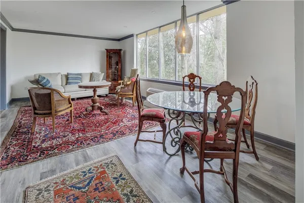 a view of a dining room with furniture a rug and wooden floor