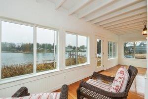 87 Tahanto Road Pocasset, MA 02559 - Photo 13 of 29 a bedroom with a bed and a large window with balcony view