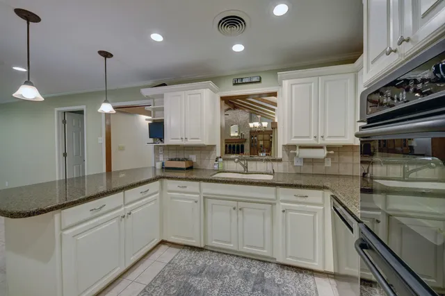 a kitchen with white cabinets and appliances