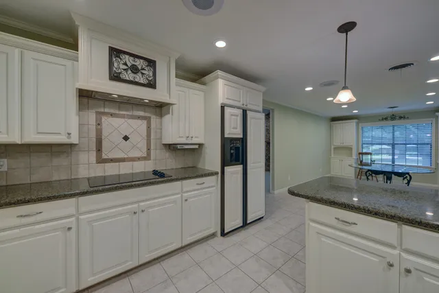 a kitchen with stainless steel appliances granite countertop a sink a refrigerator and a granite counter tops