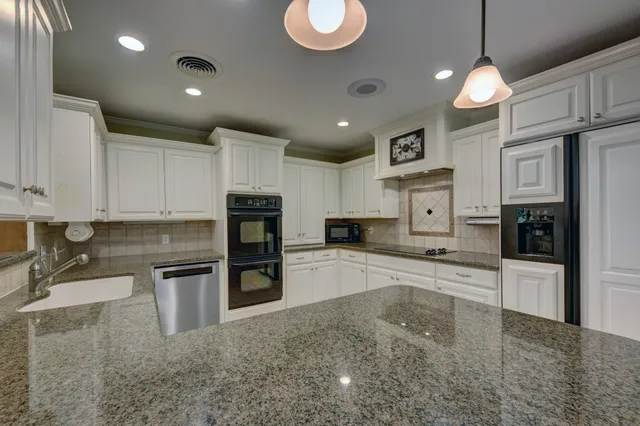 a large kitchen with cabinets and stainless steel appliances