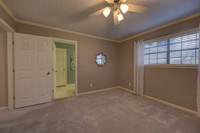 a view of an empty room with a chandelier fan