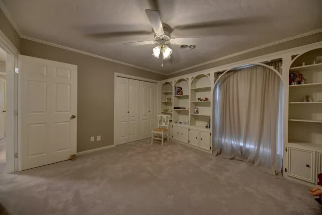 a view of a livingroom with a chair and chandelier fan