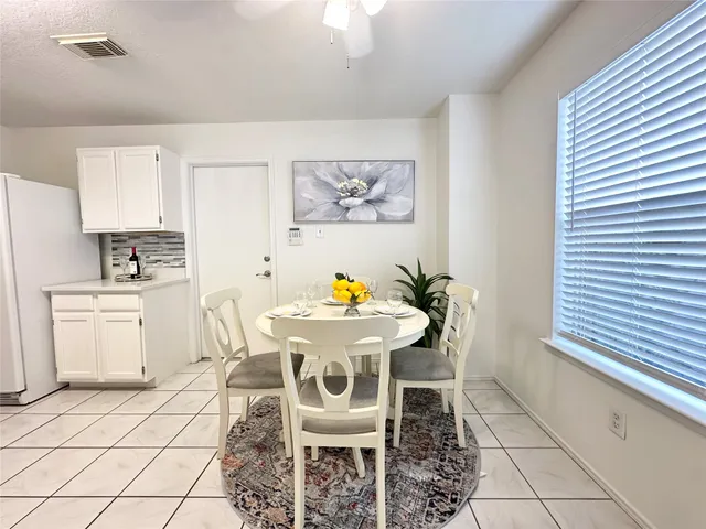 a kitchen with a sink chairs and white cabinets