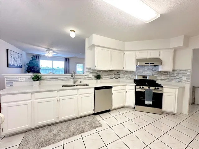 a kitchen with a stove top oven and cabinets