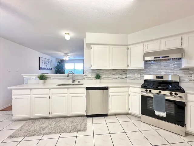 a kitchen with stainless steel appliances a refrigerator sink stove and cabinets