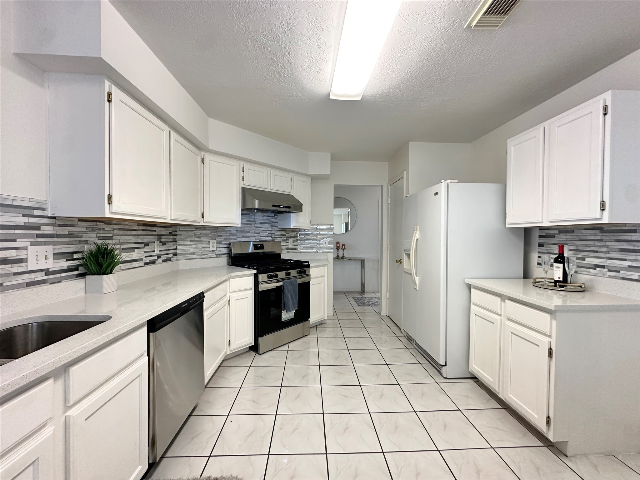 8223 Golf Green Circle Houston, TX 77036 - Photo 19 of 38 a kitchen with stainless steel appliances a refrigerator sink stove and cabinets