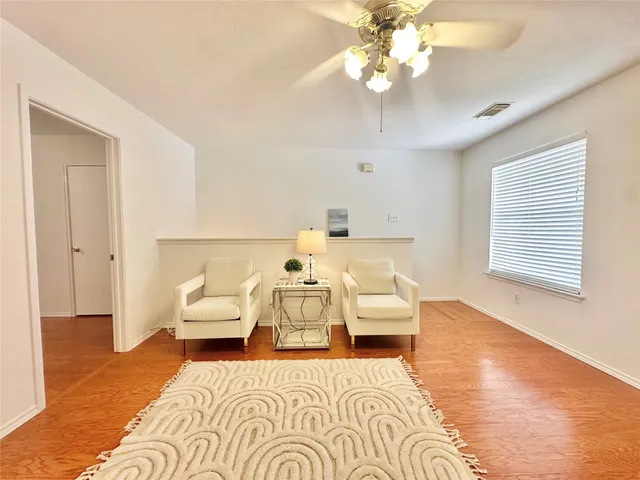 a view of a bedroom with a bed and wooden floor