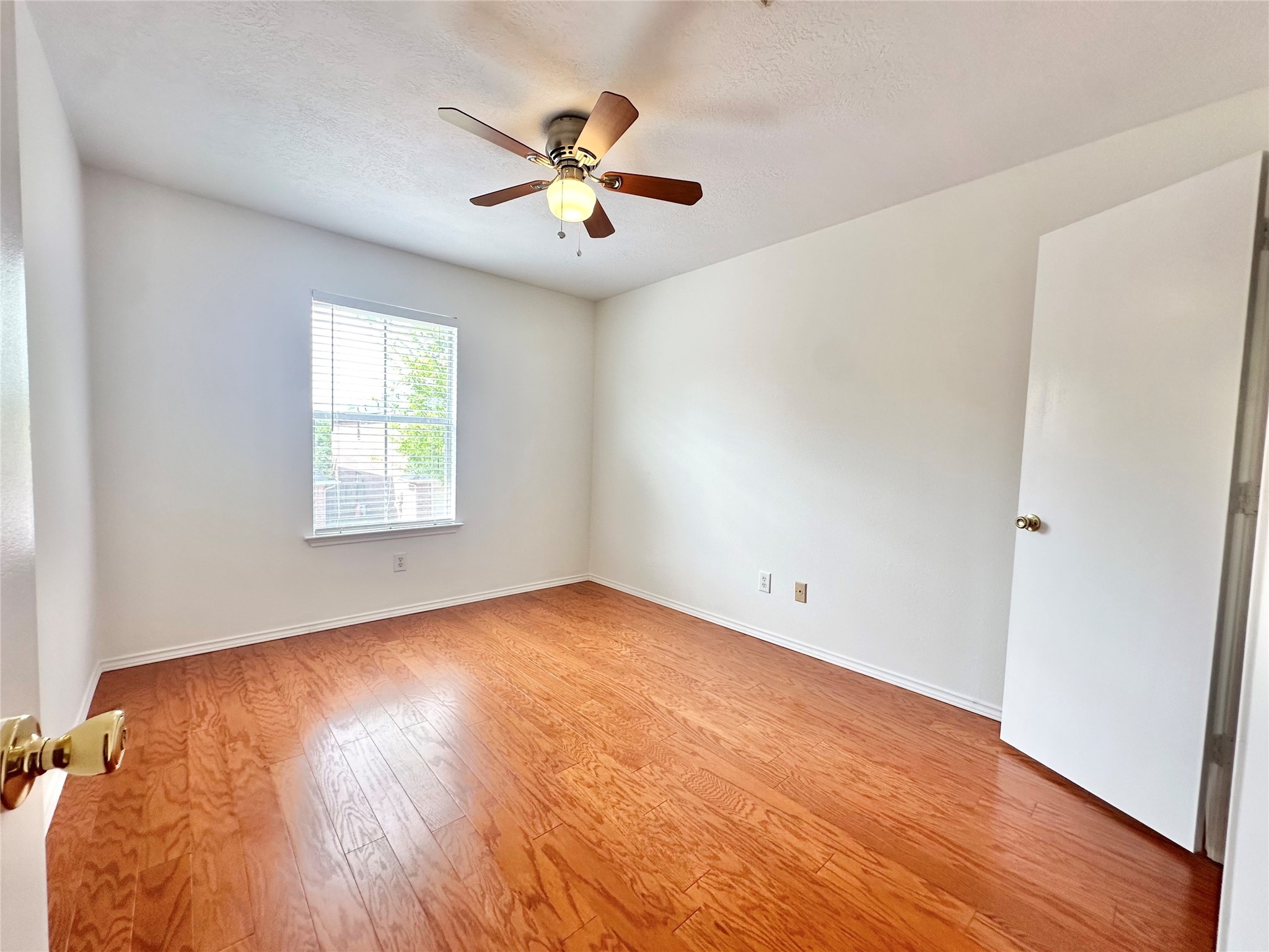 8223 Golf Green Circle Houston, TX 77036 - Photo 29 of 38 an empty room with wooden floor chandelier fan and windows