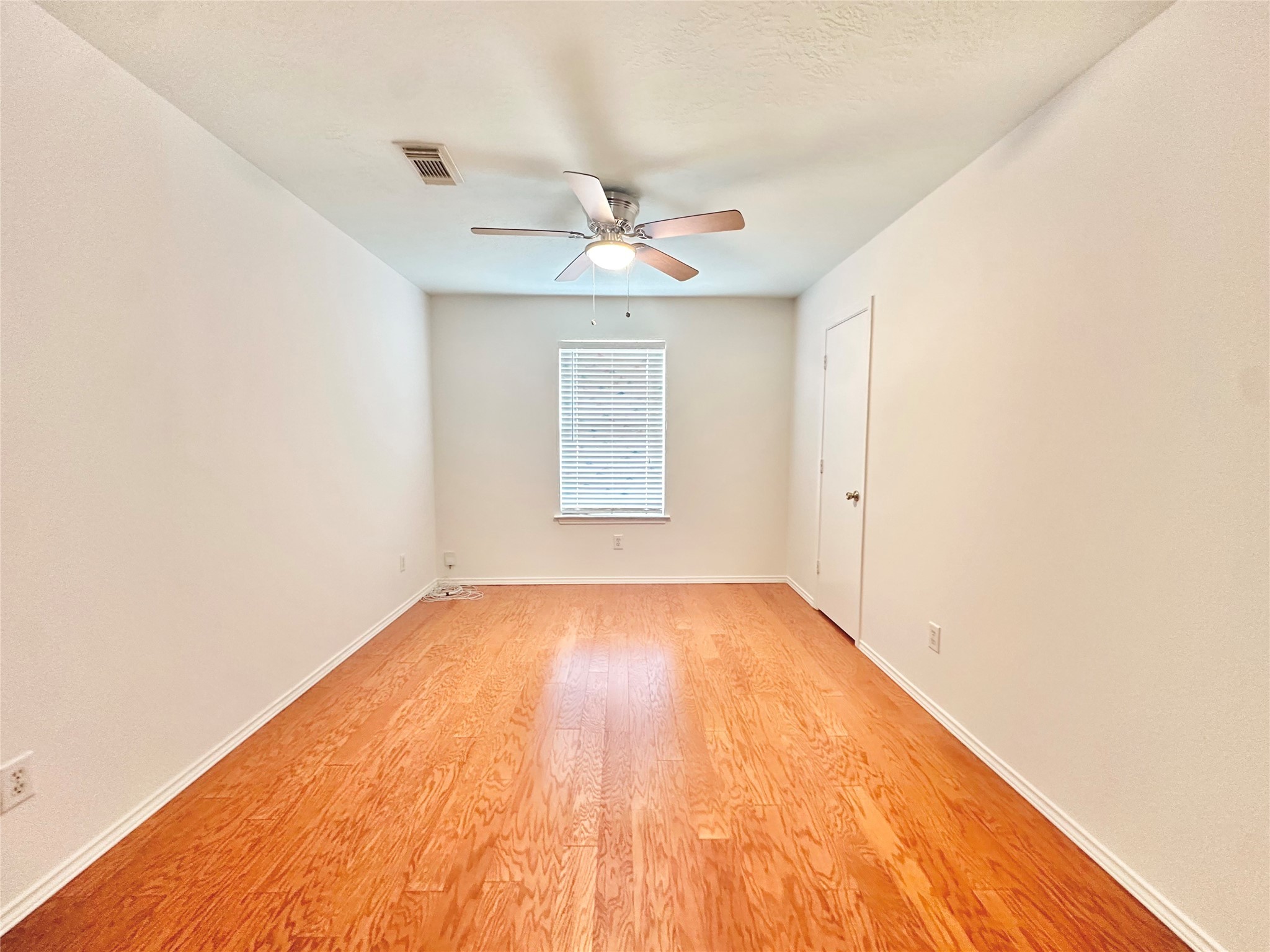 8223 Golf Green Circle Houston, TX 77036 - Photo 30 of 38 an empty room with wooden floor ceiling fan and windows