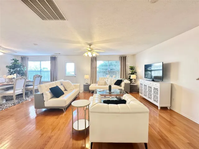 a living room with furniture and a wooden floor