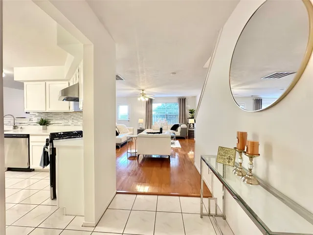 a view of a hallway with wooden floor and glass windows