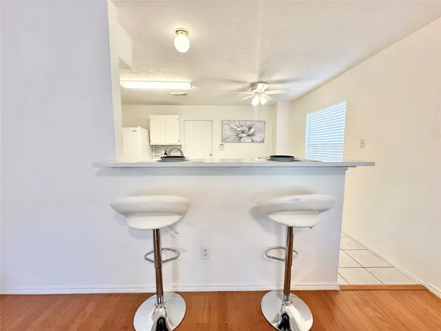 a dining room with furniture a rug and a kitchen view