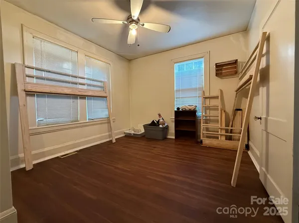 a view of a livingroom with wooden floor and ceiling fan