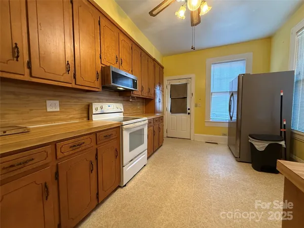 a kitchen with stainless steel appliances granite countertop a refrigerator a stove and a sink