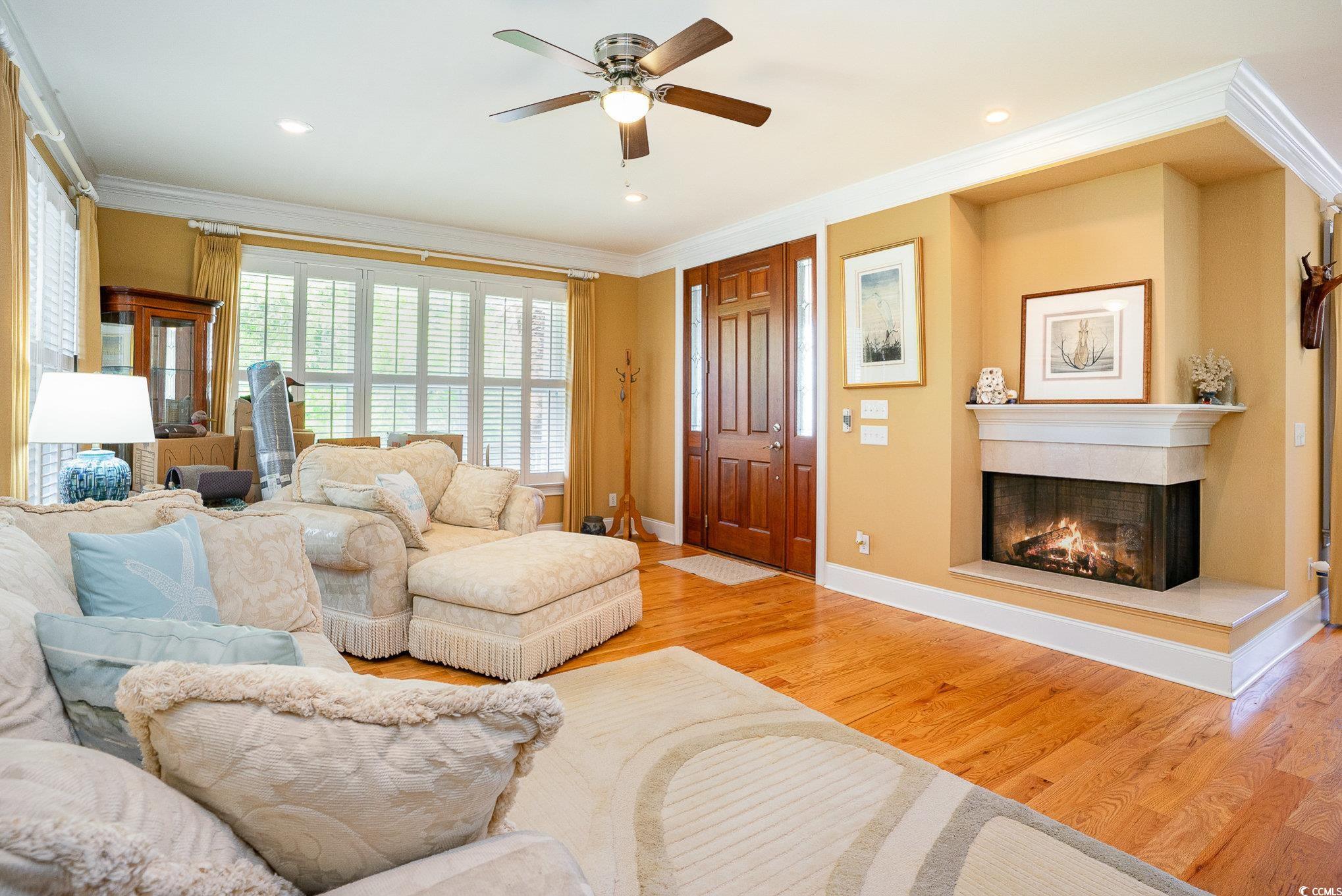 9 Gasparilla Drive Murrells Inlet, SC 29576 - Photo 6 of 40 Living area with baseboards, ceiling fan, a fireplace, crown molding, and wood finished floors