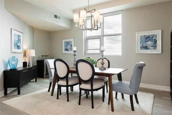 a dining room with furniture a chandelier and window