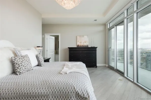 a bedroom with a bed and a dresser next to a window