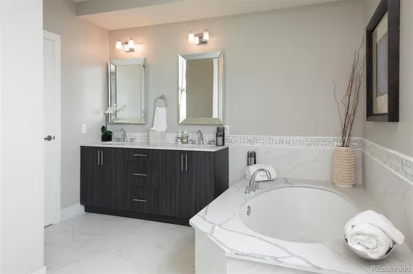 a bathroom with a tub sink and mirror