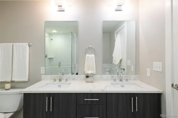 a bathroom with double sink and a mirror