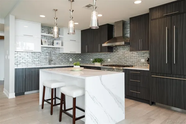 a kitchen with kitchen island granite countertop wooden cabinets and a refrigerator