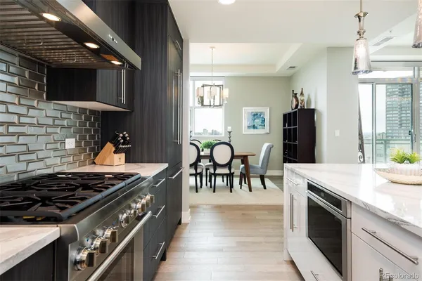 a kitchen with stainless steel appliances granite countertop a stove a sink and a microwave