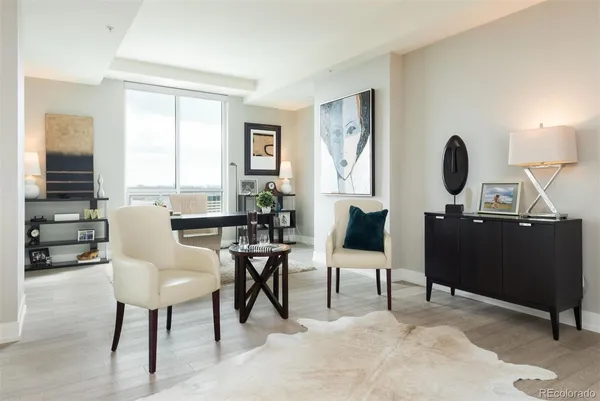 a view of a workspace with furniture and a large window