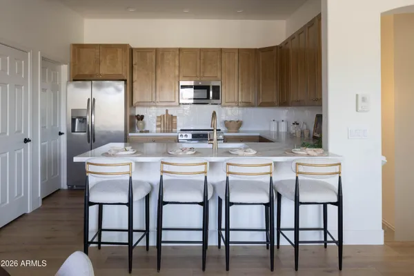 a kitchen with stainless steel appliances granite countertop a sink a microwave a stove and refrigerator