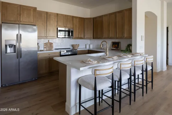 a kitchen with stainless steel appliances granite countertop a sink a stove a refrigerator cabinets and a sink