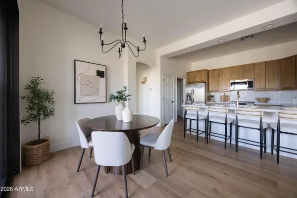 a kitchen with a dining table chairs and refrigerator