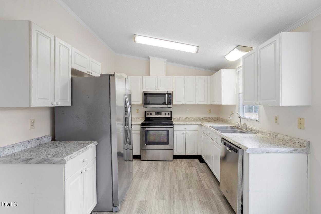 919 Red Mountain Road Rougemont, NC 27572 - Photo 18 of 32 a kitchen with granite countertop a sink stove and refrigerator