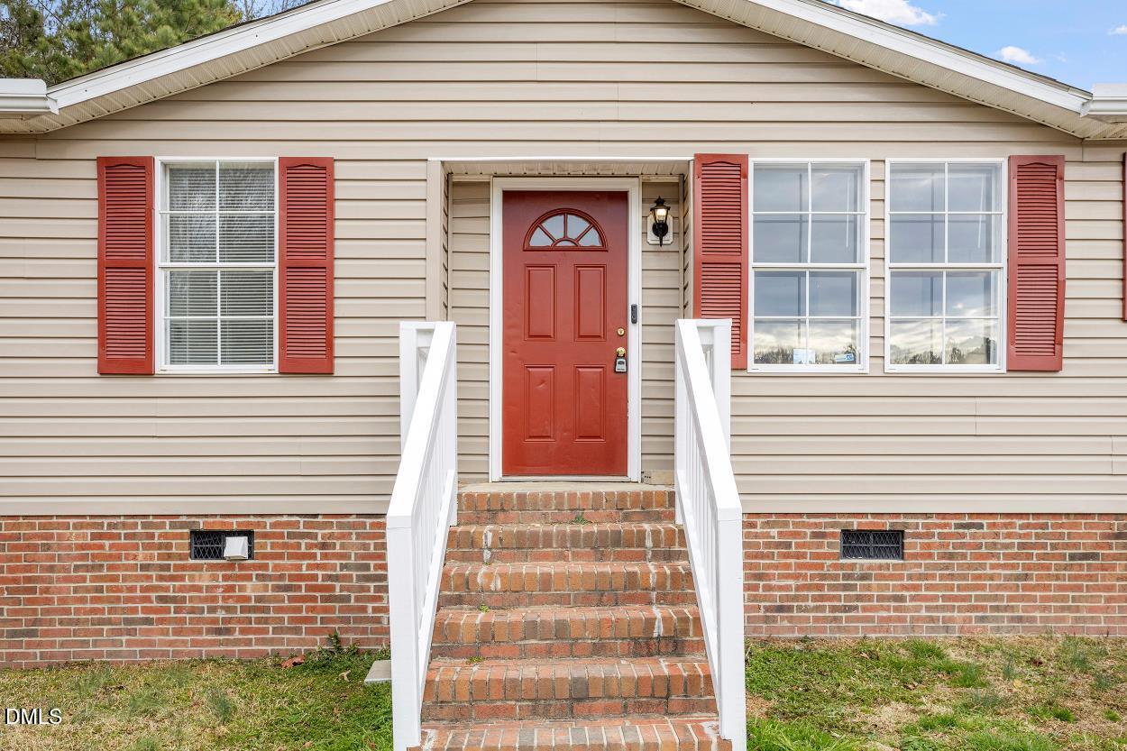 919 Red Mountain Road Rougemont, NC 27572 - Photo 4 of 32 a front view of a house with large windows