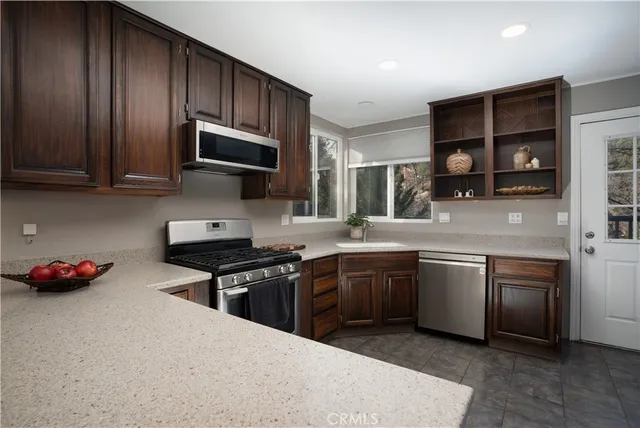a kitchen with stainless steel appliances granite countertop a stove sink and cabinets