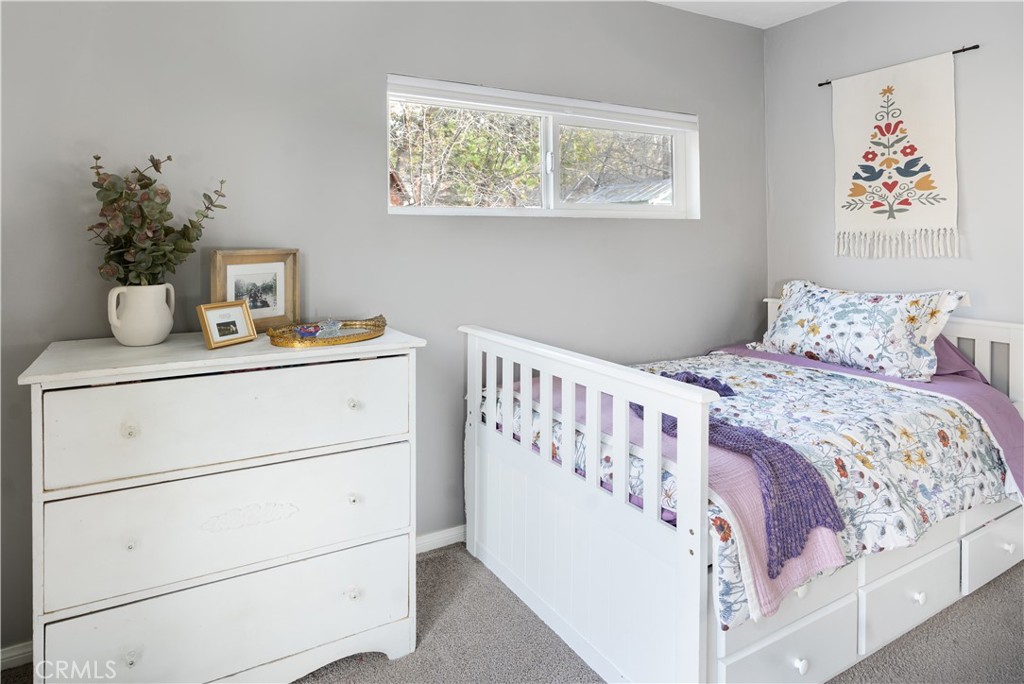 32958 Squirrel Lane Running Springs, CA 92382 - Photo 19 of 40 a bedroom with a bed and a table in it