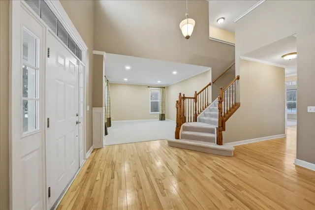 a view of a hallway with wooden floor and staircase