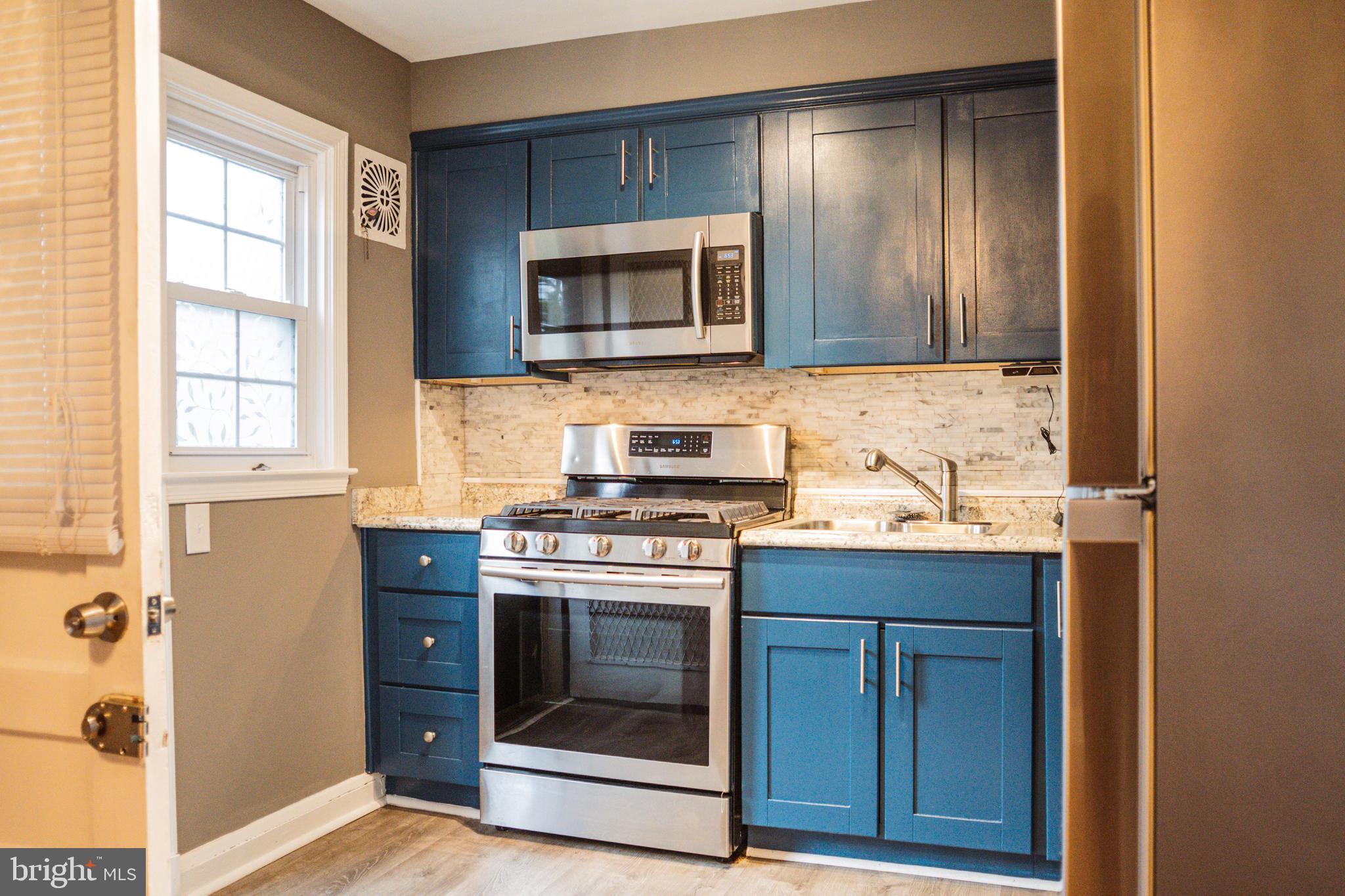 3402 Mayfair Road Baltimore, MD 21207 - Photo 13 of 48 a kitchen with a stove and a microwave